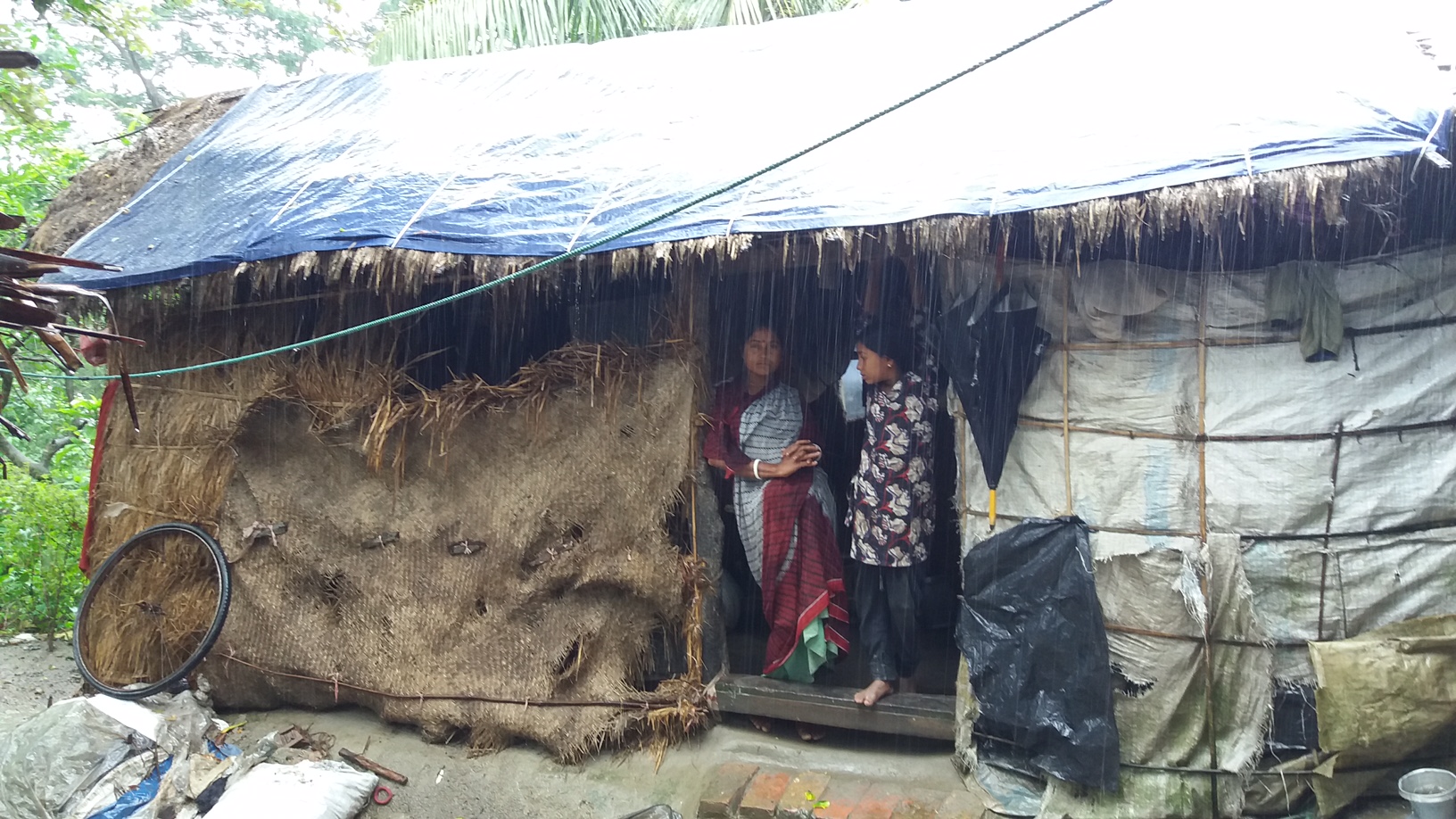 Woman in Bangladesh staying at their house while it is strongly raining