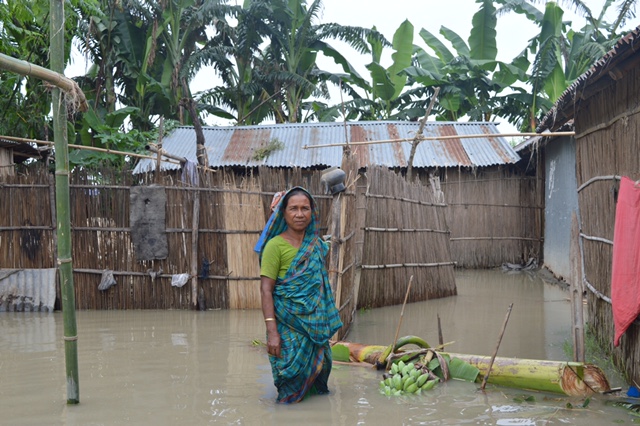 Woman standing in flooded house in bangladesh